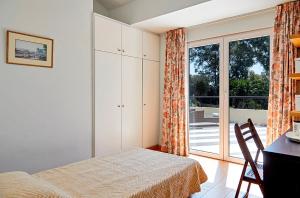 a bedroom with a bed and a sliding glass door at Helion Apartments - Parallel in Gouvia