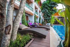 an outdoor patio with chairs and a swimming pool at Villa Sirilanna Hotel in Chiang Mai