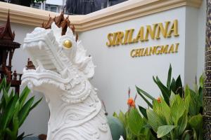 a white statue in front of a santamaria chinese sign at Villa Sirilanna Hotel in Chiang Mai