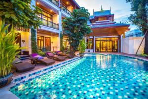 a swimming pool in the backyard of a house at Villa Sirilanna Hotel in Chiang Mai