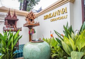 a building at the entrance to a resort with a vase at Villa Sirilanna Hotel in Chiang Mai