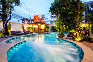 a swimming pool in a hotel at night at Villa Sirilanna Hotel in Chiang Mai