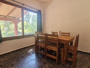 a dining room with a wooden table and chairs at La vuelta y el vaso in Playa Verde