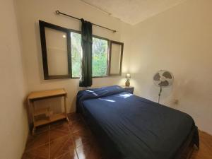 a bedroom with a bed and a window at La vuelta y el vaso in Playa Verde