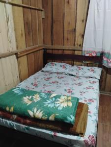 a bed in a room with a bedspread with flowers at Casa da Duda in São Gabriel