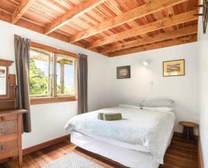 a bedroom with a bed and a wooden ceiling at The Innlet, Country Apartments and Cottages in Collingwood