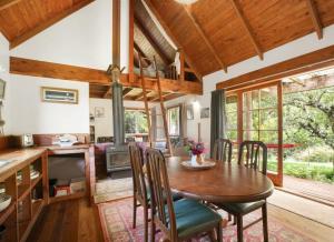 a kitchen and dining room with a wooden table and chairs at The Innlet, Country Apartments and Cottages in Collingwood