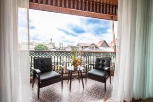 a balcony with two chairs and a table with a view at Villa Sirilanna Hotel in Chiang Mai