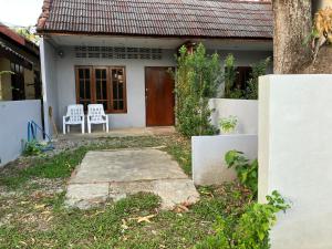 a house with a porch and two chairs in front of it at Friend Guesthouse , Kho Lanta in Ko Klang