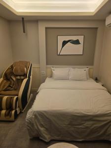 a bedroom with a large bed and a chair at DK hotel in Incheon