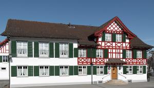 un edificio con finiture rosse e verdi di Gasthof Eisenbahn a Weinfelden