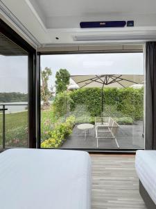 a bedroom with a bed and a patio with an umbrella at Mont Du Kwai Resort in Ban Yang (2)