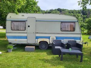 a caravan parked in a field with a table and chairs at Dani's Wohnwagen B&B in Ramsen