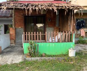 a house with a green fence in front of it at Friend Guesthouse , Kho Lanta in Ko Klang