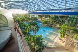 an indoor mall with a pool and palm trees at Hotel Victory Therme Erding in Erding