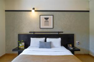 a bedroom with a large bed with two pillows at Olive Hotel Alidia Beach Resort by Embassy Group in Baga