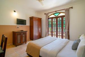 a bedroom with a large bed and a window at Olive Hotel Alidia Beach Resort by Embassy Group in Baga +70 photos