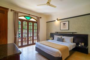 a bedroom with a large bed and a window at Olive Hotel Alidia Beach Resort by Embassy Group in Baga