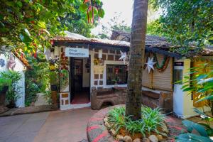 a store front of a house with a tree at Olive Hotel Alidia Beach Resort by Embassy Group in Baga