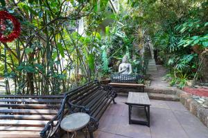 a park bench with a statue in a garden at Olive Hotel Alidia Beach Resort by Embassy Group in Baga