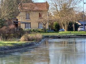 a house next to a body of water at Au calme, 2 grandes chambres, 65m2 , devant le canal, animaux ok in Lere