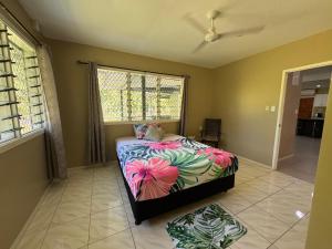 a bedroom with a bed with a colorful bedspread at Secure Vailima Home with Fale in Apia