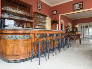 a bar with a row of stools in a restaurant at Le Renaissance in Montdidier