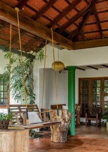a porch with a swing and a tree stump at Chetty's Mane by Raho - Estate-View Heritage Stay in Siddapur