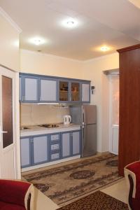 a kitchen with blue cabinets and a refrigerator at Shushanik Home in Jermuk