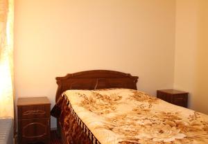 een slaapkamer met een bed en twee nachtkastjes bij Shushanik Home in Dzjermoek