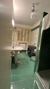 a bathroom with a sink and a green floor at Appartamento luminoso in Parma +21 photos