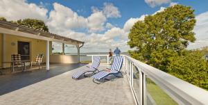 balcón con 2 sillas, mesa y vistas al océano en Gästehaus Niederhof en Sundhagen-Niederhof