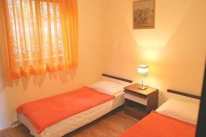 1 dormitorio con 2 camas y mesa con lámpara en Apartments Grbesa, en Trogir