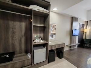 a room with a sink and a desk with a mirror at Ajang Hotel in Miri