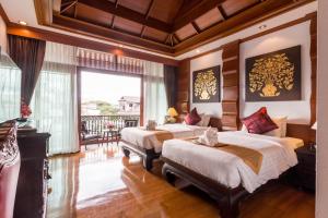 a bedroom with two beds and a balcony at Villa Sirilanna Hotel in Chiang Mai +37 photos