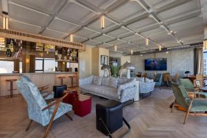 a living room with couches and chairs and a bar at Publica Isrotel, Autograph Collection in Herzliya