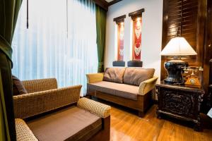a living room with a couch and a chair at Villa Sirilanna Hotel in Chiang Mai
