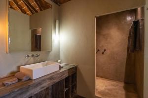 a bathroom with a white sink and a shower at Shakawe River Lodge in Shakawe +30 photos