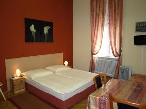 1 dormitorio con cama, mesa y ventana en Pension Gross, en Viena