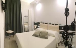1 dormitorio con 2 camas blancas y espejo en B&B Acqua di Sale, en Manfredonia