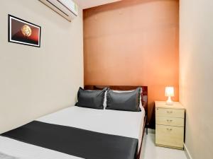 a small bedroom with a bed and a night stand at HOTEL O ORR RESIDENCY in Hyderabad