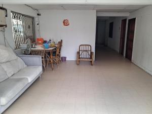 a living room with a couch and a table and chairs at Fortune Room Stay 3 in Sandakan