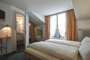 una camera da letto con due letti e una grande finestra di Gasthof Eisenbahn a Weinfelden