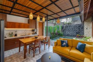 a kitchen and living room with a table and a couch at The Bulih Ubud in Ubud