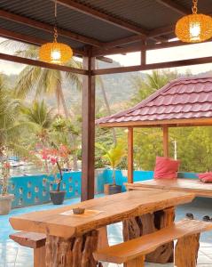 a picnic table on a patio with a view of a pool at Anugrah Hotel Teluk Nara in Teluknarat