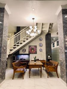 a dining room with a table and a staircase at Wisma Lovebird in Kalianget