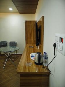 a kitchen with a counter with a tea kettle and a table at Hotel aditya palace in Padrauna +9 photos