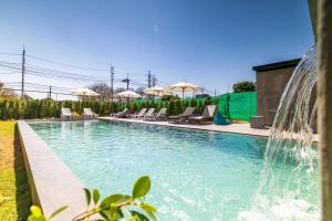 a swimming pool with a fountain in a yard at Phuket Five Fortune Holiday Hotel in Rawai Beach