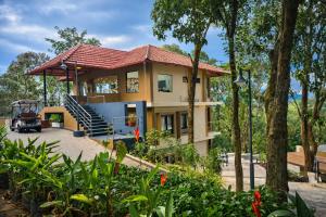a house with a red roof at Nirjhara Coorg in Somvārpet