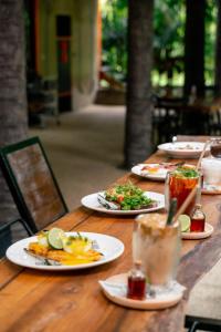 ein Holztisch mit Tellern voller Essen darauf in der Unterkunft WOW PHUKET in Phuket + 37 Fotos